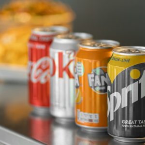 two coca cola cans on stainless steel table